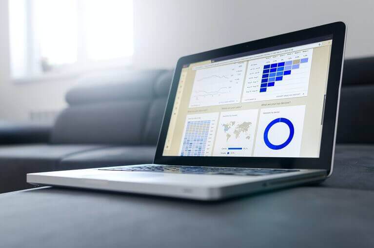A laptop displaying traffic graphs for a blogger, placed on a couch.