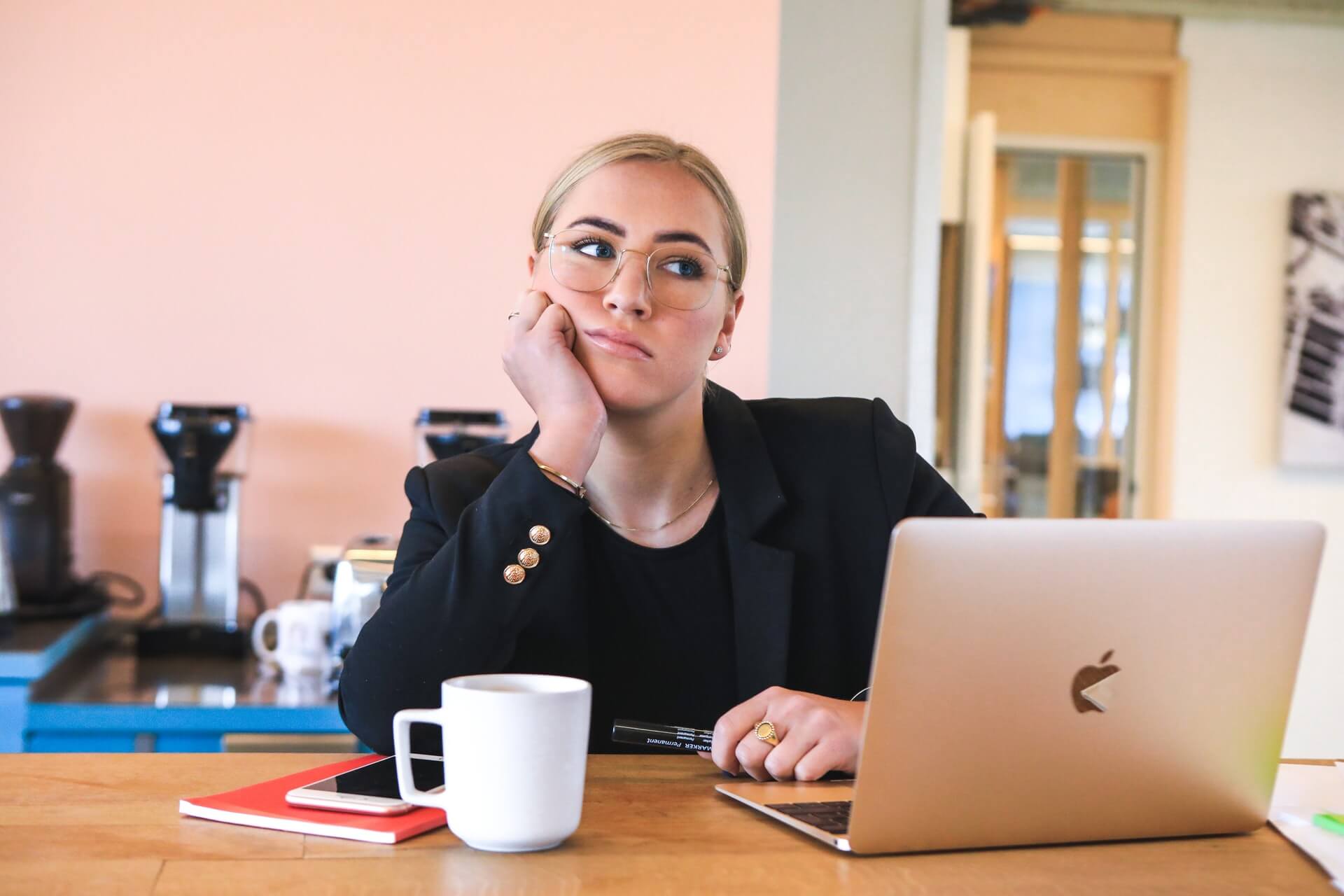A woman blogging at a desk with a laptop.