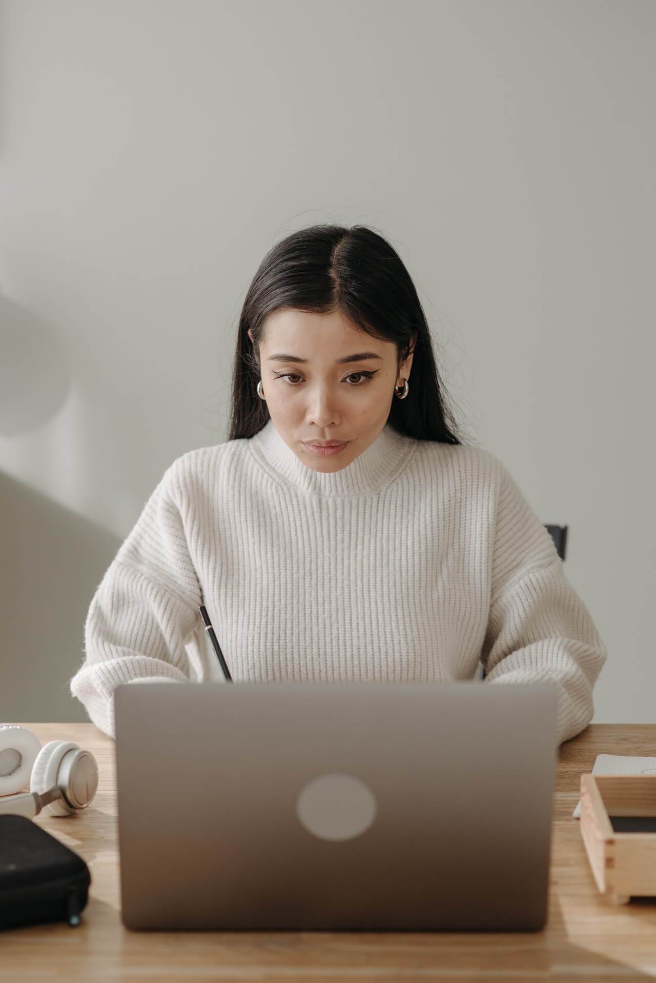 A woman utilizing a laptop to optimize SEO through blogging.