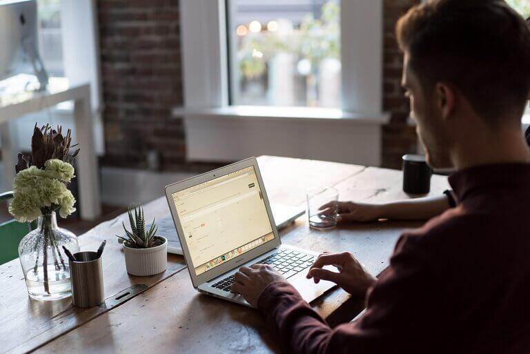 A couple applying copywriting tips while working on a laptop at a desk.