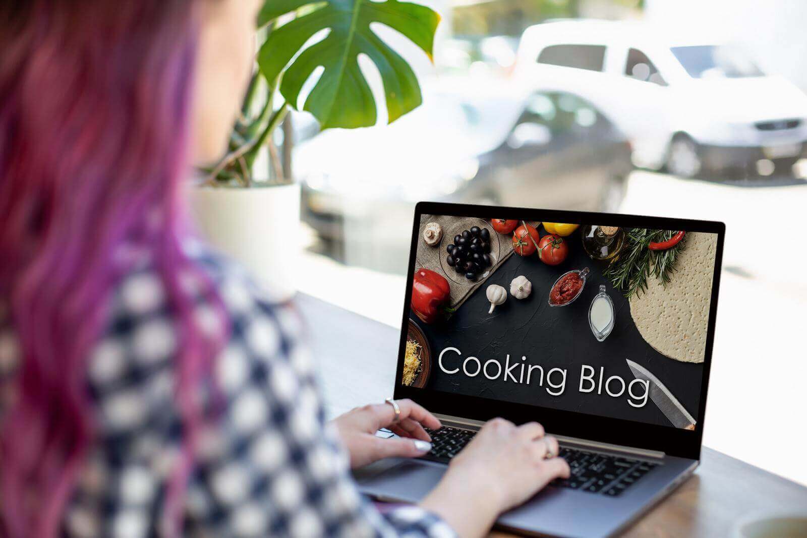 A woman using a laptop to browse a cooking blog.