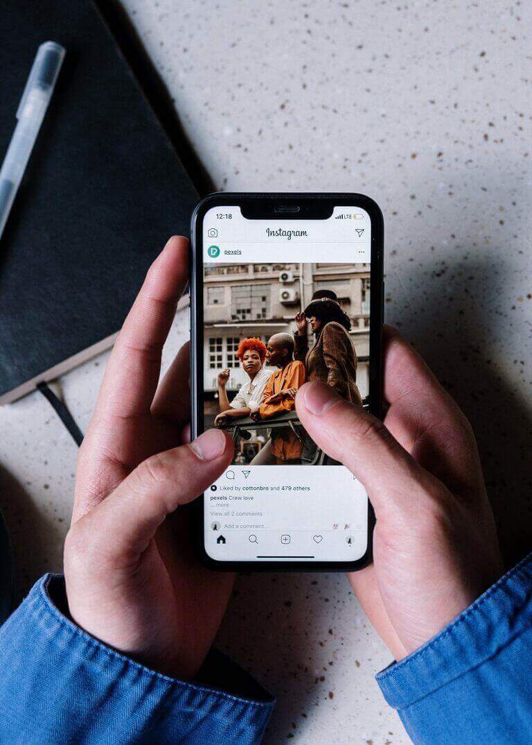 A person holding a phone with an Instagram engagement.