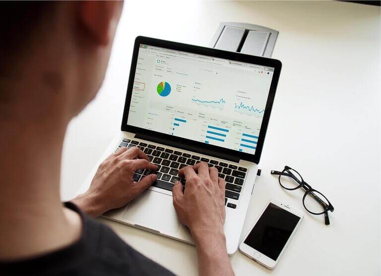 A person comparing human and AI copywriting on a laptop.