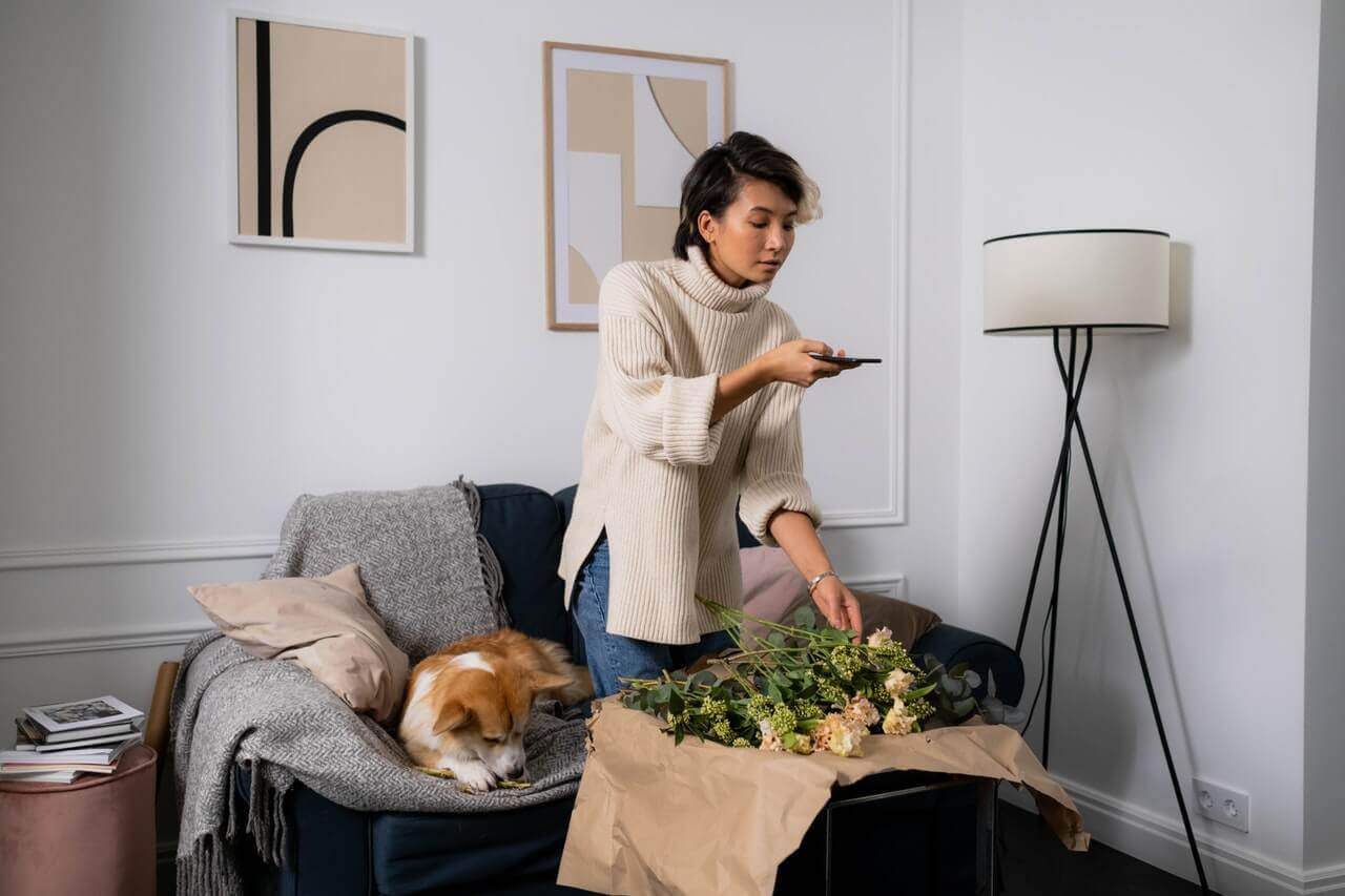 A woman creatively earns money online while enjoying a cozy living room.