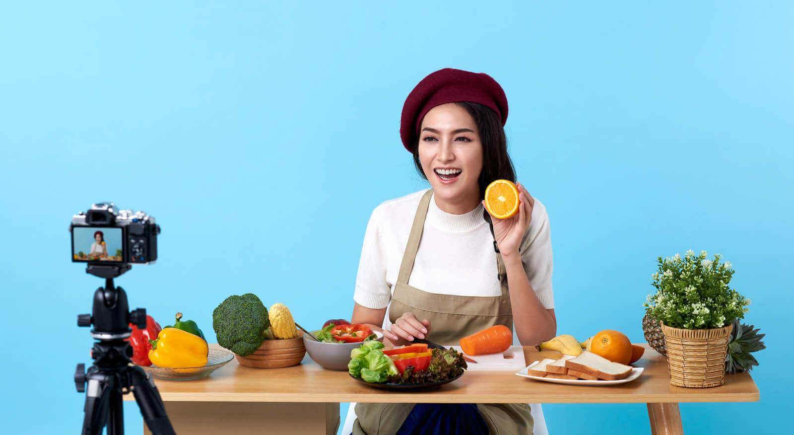 A woman is sitting at a table with food, thinking of becoming a copywriter.