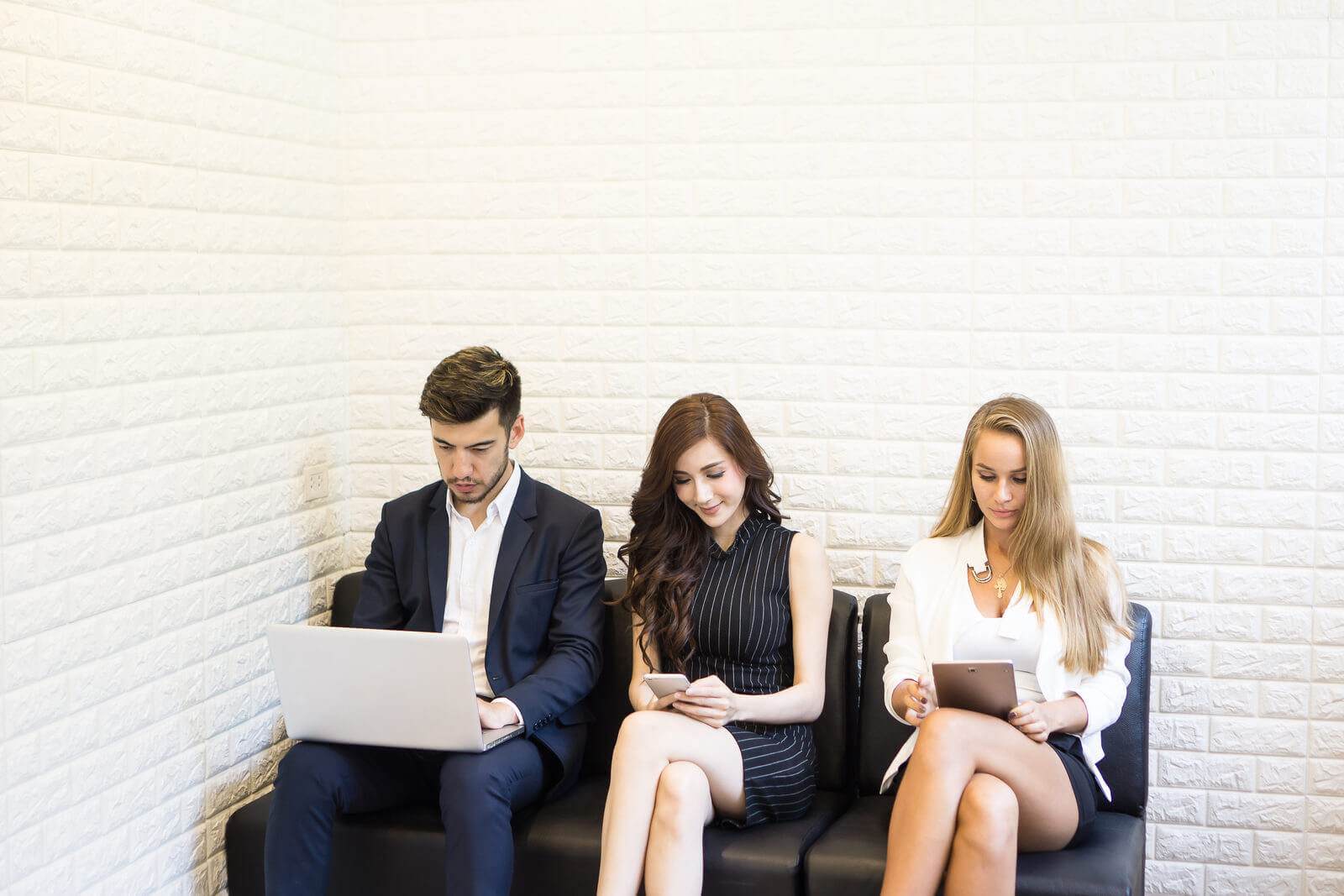 A group of business people sitting on a bench with laptops, wondering about the 5 types of copywriting.