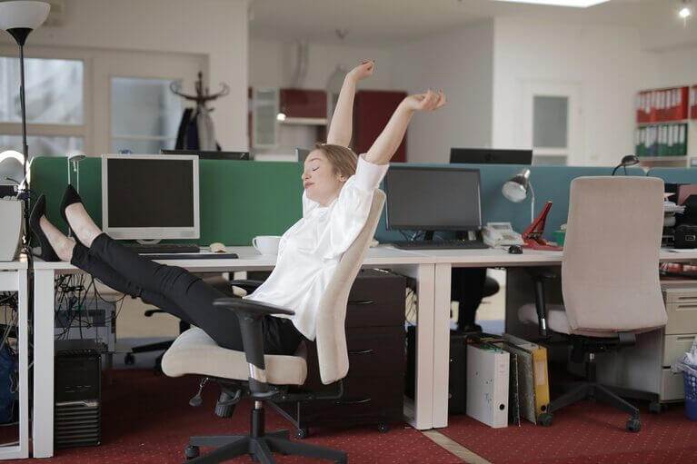 A woman is sitting in an office chair, demonstrating the effects of using an AI writer to publish more content and increase rankings.