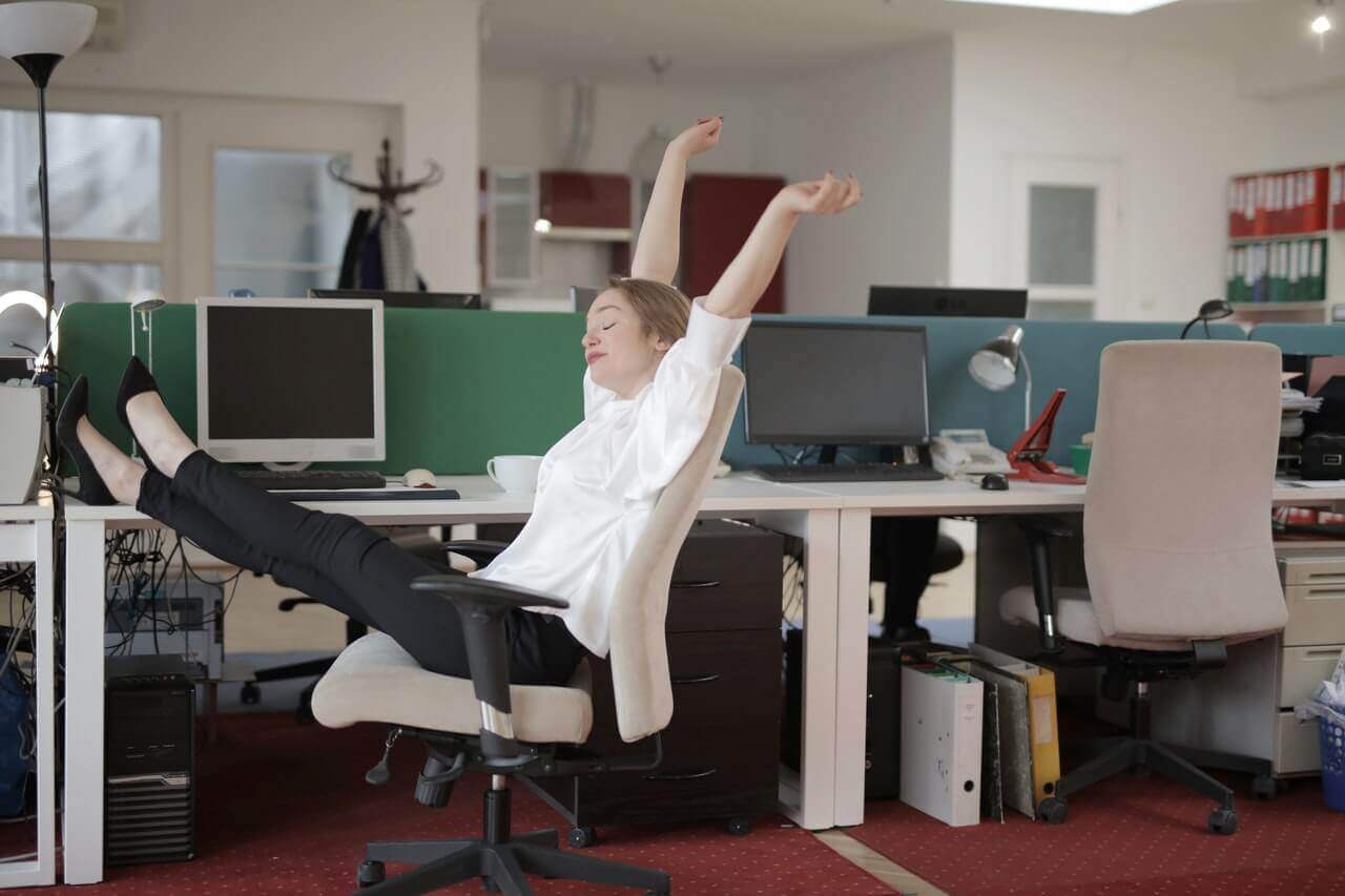 A woman is sitting in an office chair, demonstrating the effects of using an AI writer to publish more content and increase rankings.
